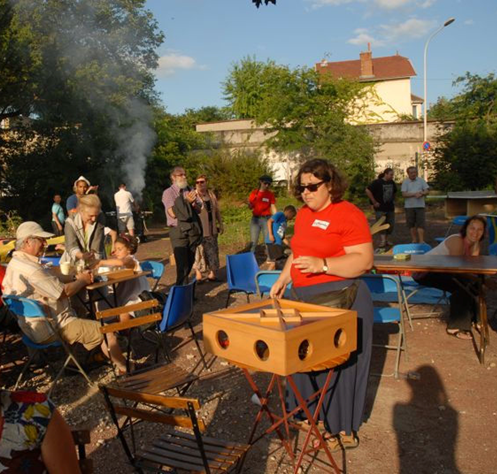 Évènement festif en lien avec la pépinière participative. Des habitants sont assis à des tables et jouent à des jeux