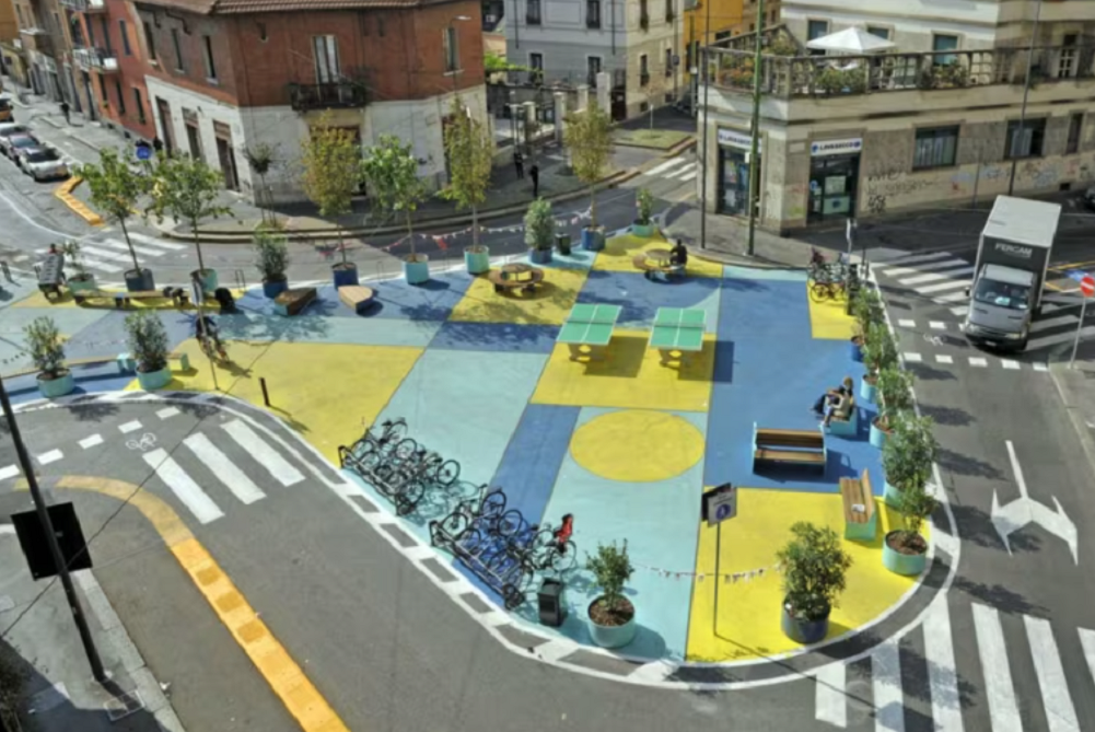 Une rue colorée avec des formes bleues et jaunes avec des bancs et un porte-vélos.