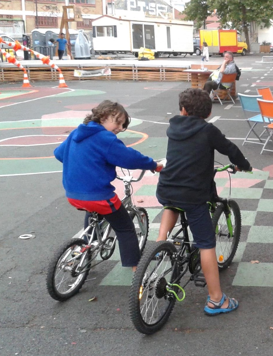 Enfants faisant du vélo sur la place