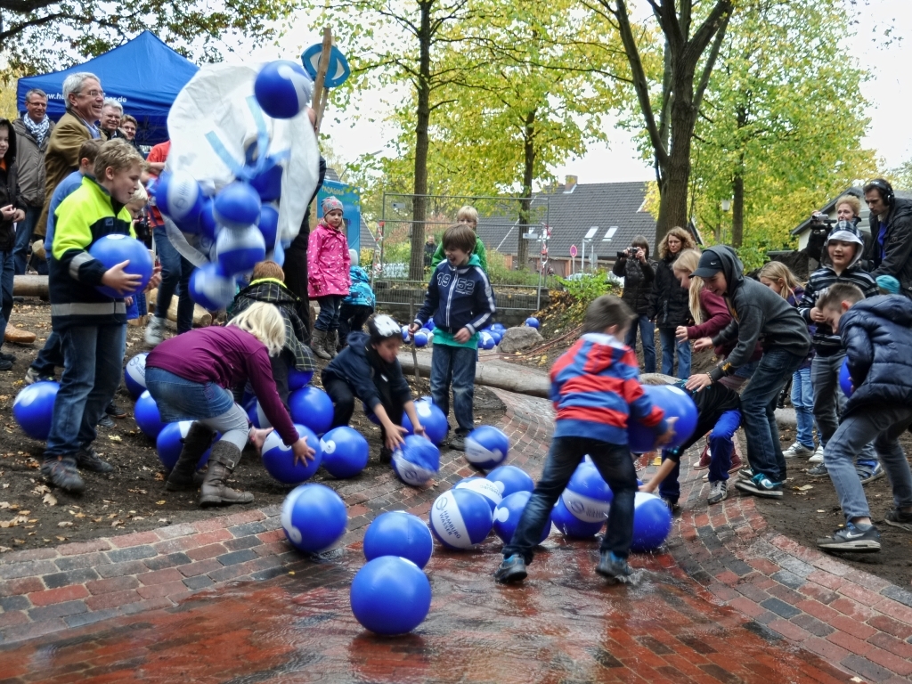 Enfants jouant dans un lit d'eau avec des ballons