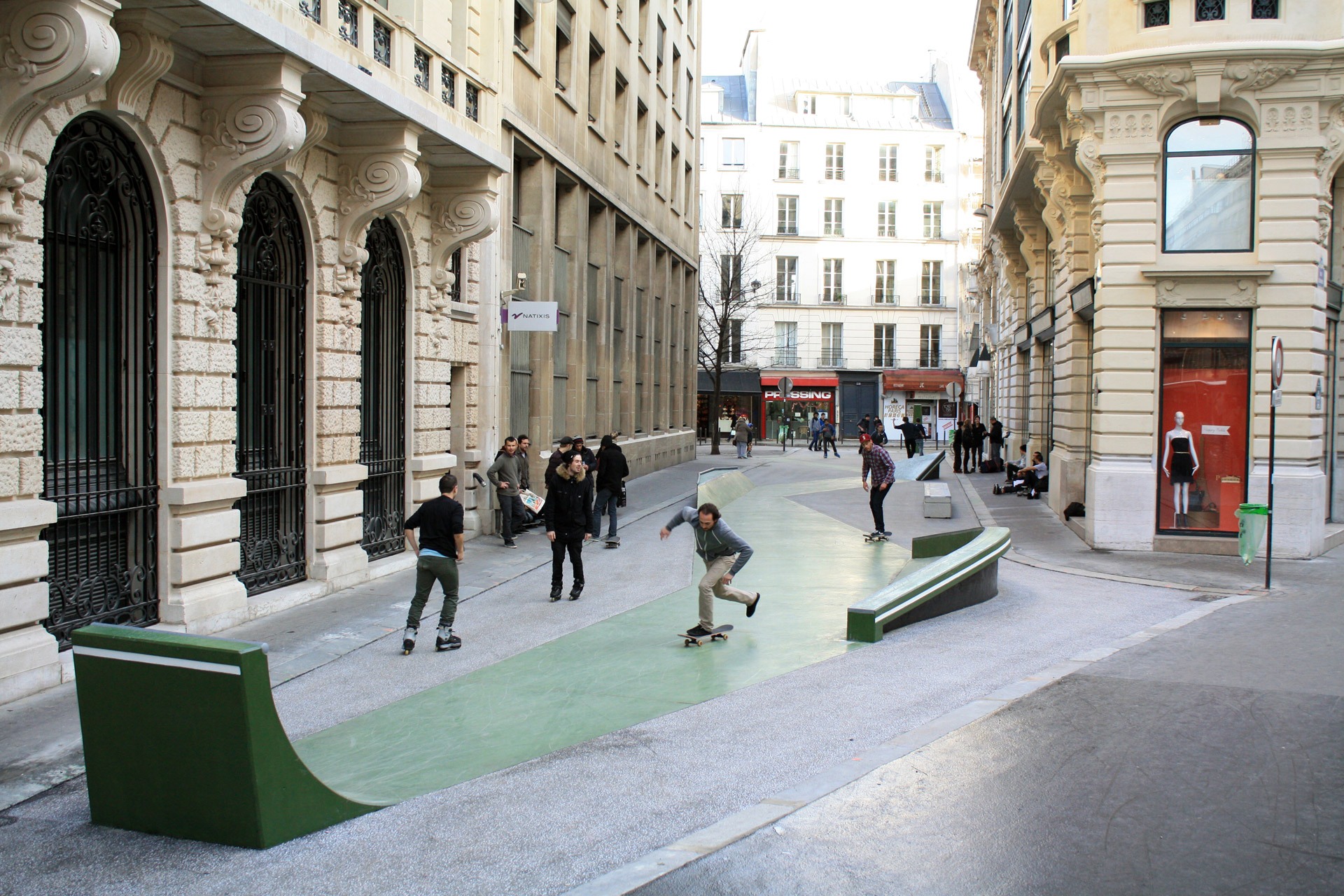 Espace de glisse installé rue Léon Cladel à Paris. Des jeunes hommes font du skate et du roller sur la piste