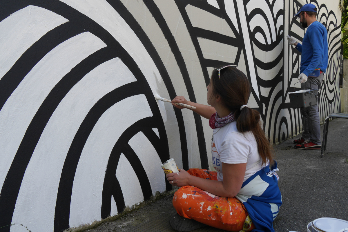 Une femme peint un mur