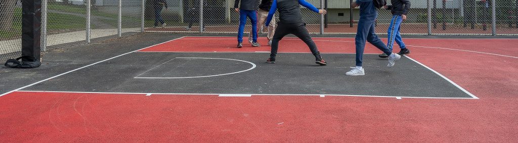 Terrain de basket ball 3X3 avec 5 adolescents qui jouent